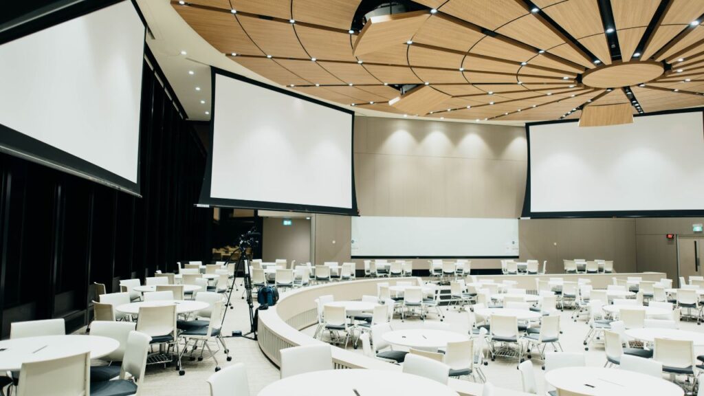 Empty venue with projector screens being prepared for a special business event