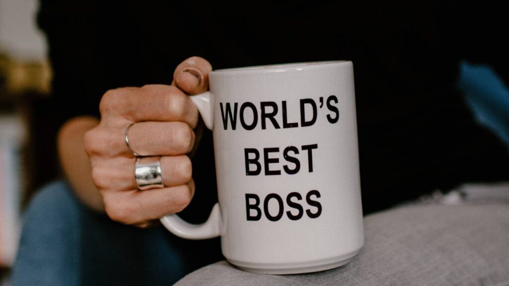 A woman holding the "world's best boss" coffee cup 